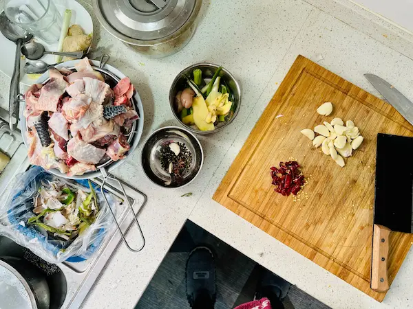 "Ingredientes frescos listos para preparar receta casera con énfasis en cocina tradicional, incluyendo pescado, vegetales y especias.