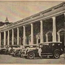 Antigua imagen de la Plaza de Mercado de Honda, Tolima, con vehículos clásicos frente a su icónica arquitectura republicana y columnas imponentes.