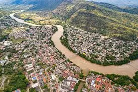 Vista aérea del río Magdalena atravesando la ciudad de Honda, Tolima, rodeada de montañas y casas coloniales.